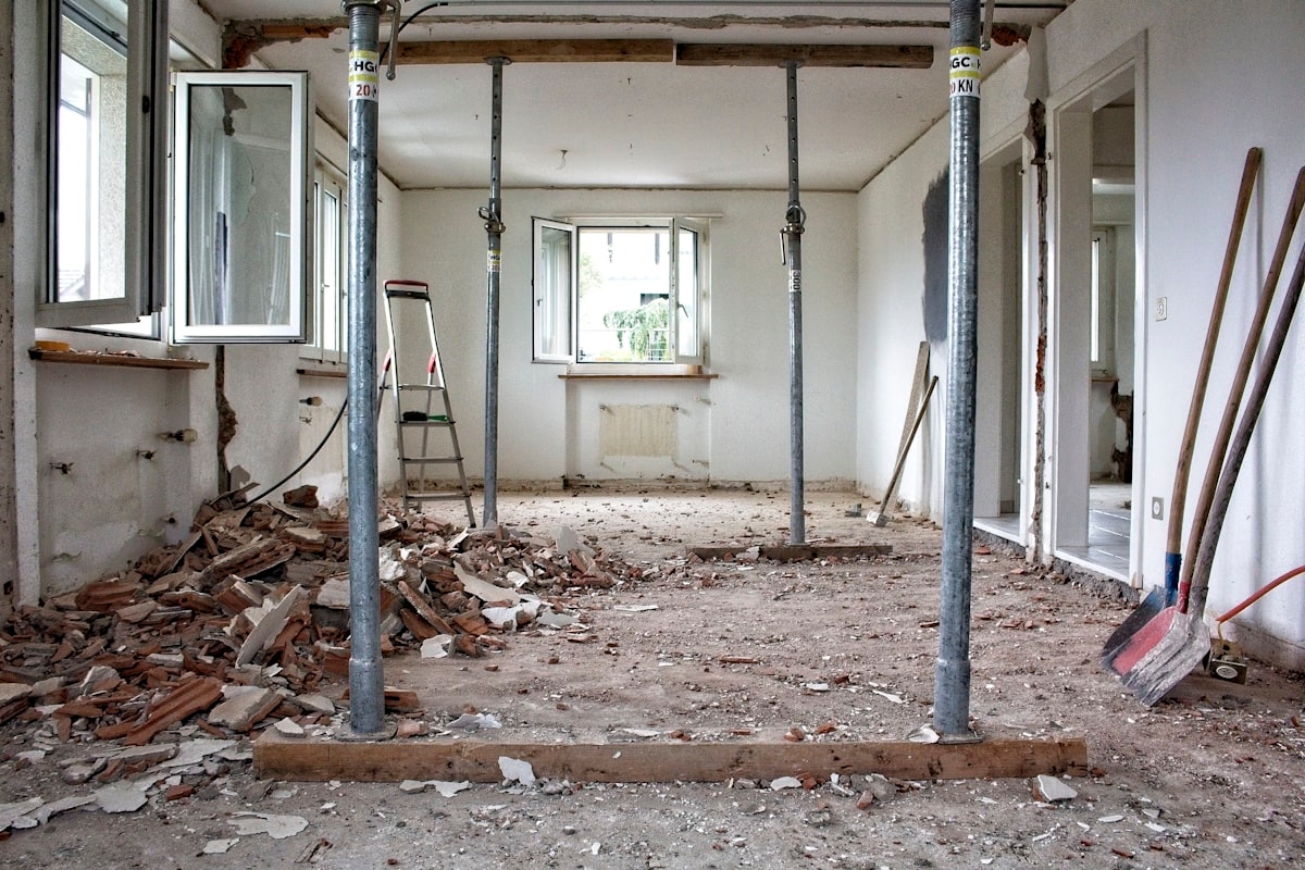 A room under renovation with construction debris, support columns and tools - Photo by Stefan Lehner on Unsplash
